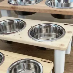 Trois gamelles pour chien en bois, sur pieds blancs, avec bols en inox. Une création artisanale française pour le repas de votre compagnon.