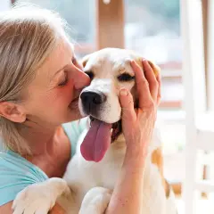 Une femme câline son chien, un moment de pur bonheur. Une véritable cure thermale avec chien pour le bien-être de tous.
