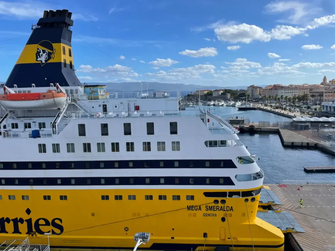 Le Mega Smeralda, un ferry de Corsica Ferries, est amarré dans un port pittoresque.