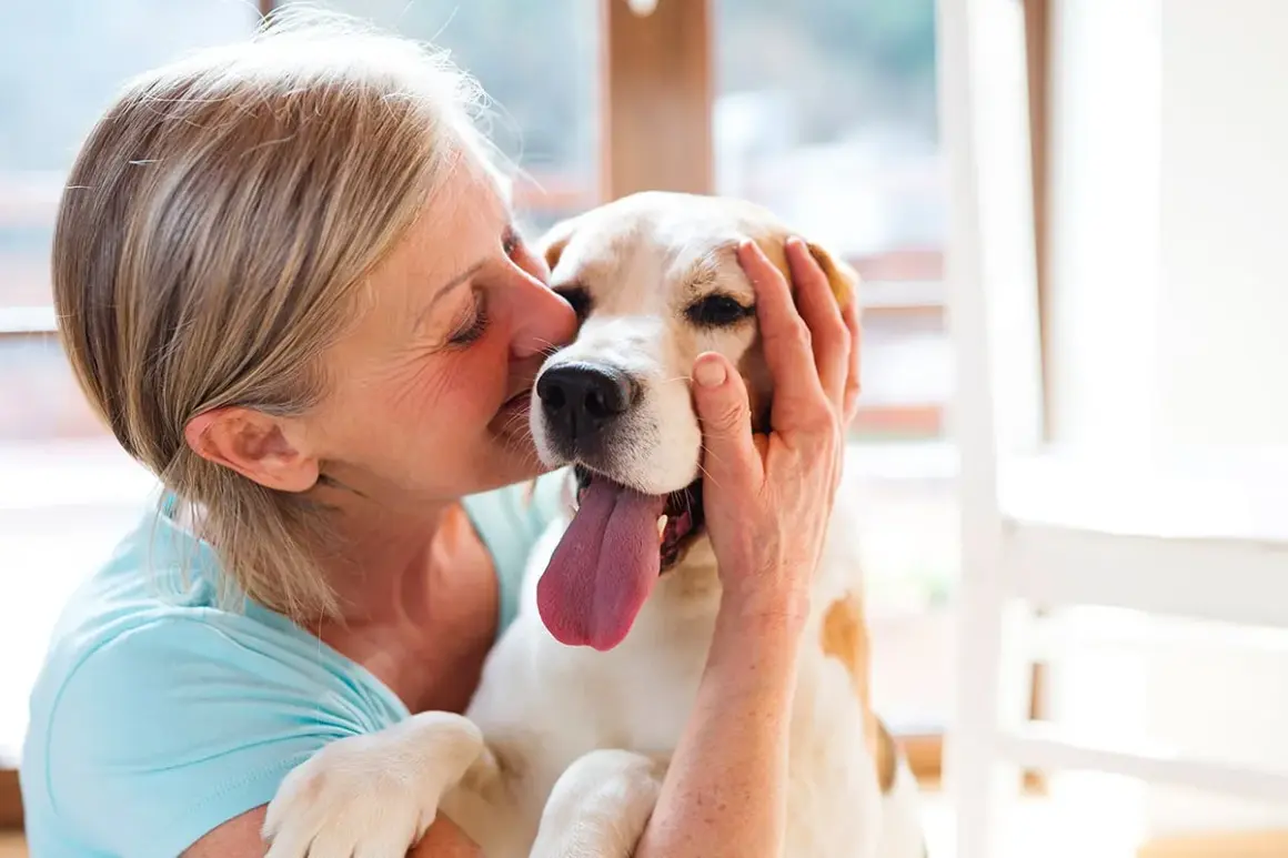 Une femme câline son chien, un moment de pur bonheur. Une véritable cure thermale avec chien pour le bien-être de tous.