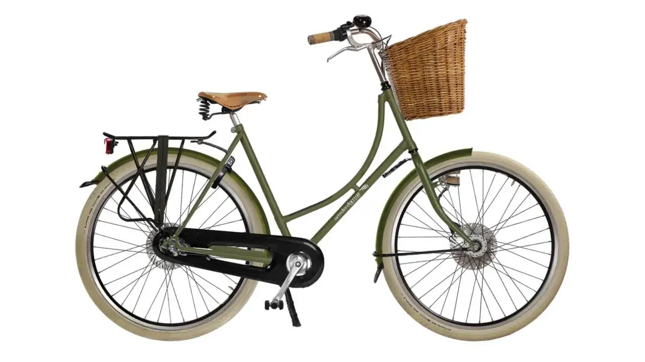 Vélo vert avec un panier en osier pour vélo à l'avant, porte-bagages arrière et selle en cuir.
