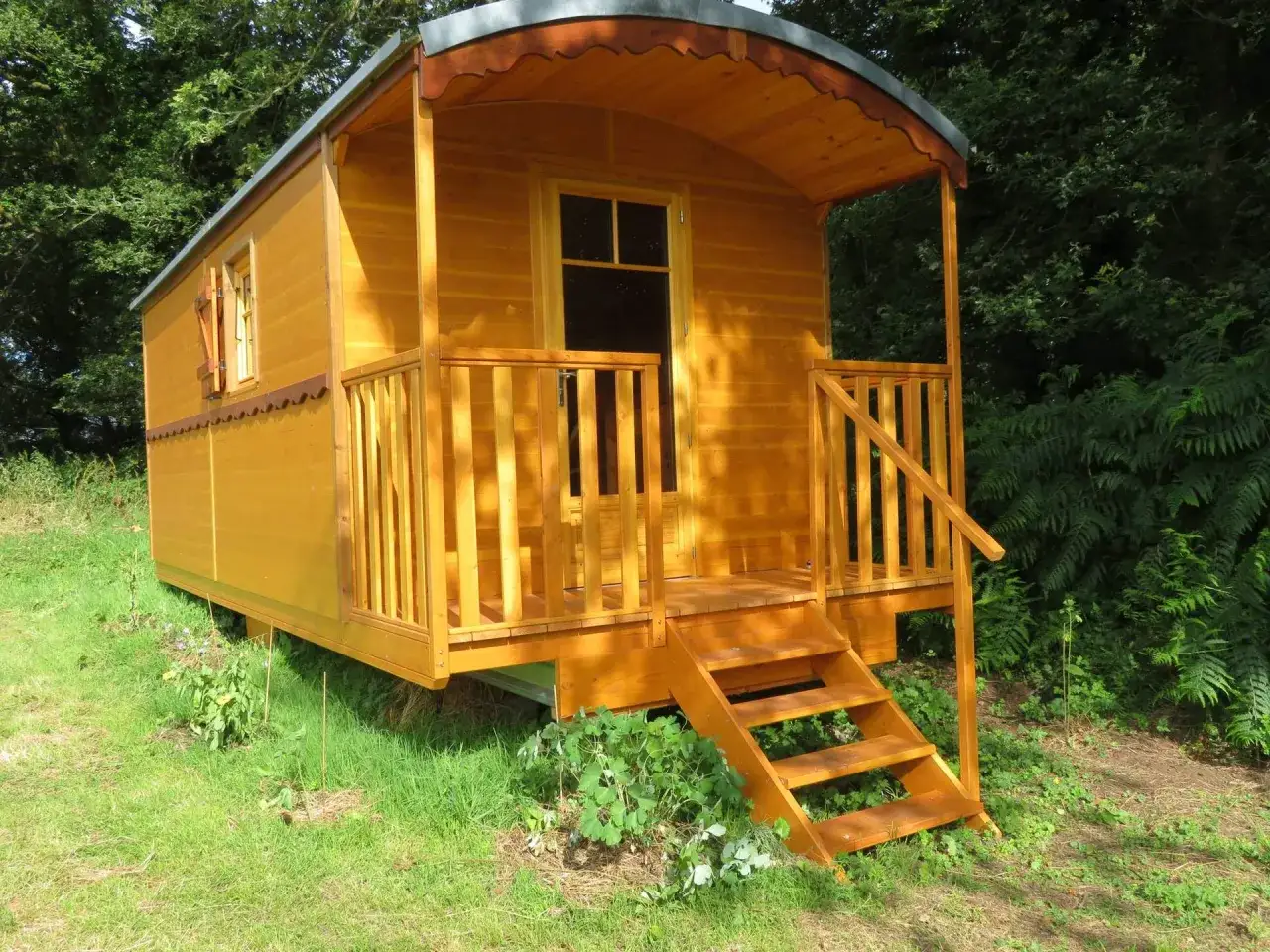 Charmante roulotte en bois, un hébergement insolite avec animaux, nichée dans la verdure. Parfait pour une escapade nature.