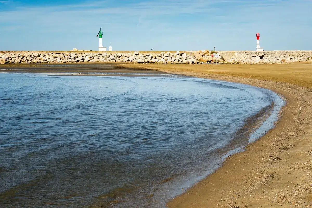 La plage du Grau-du-Roi, avec ses phares et sa digue en pierres, est un lieu idéal pour une promenade avec votre chien autorisé.