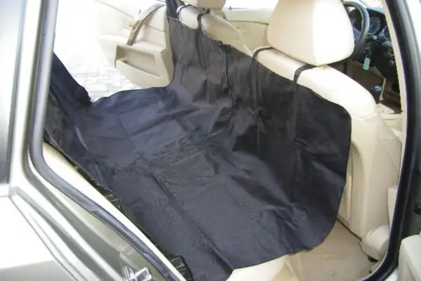 Protection siège voiture chien : une housse noire est installée sur les sièges arrière d'une voiture pour protéger l'intérieur des poils et salissures de votre compagnon.