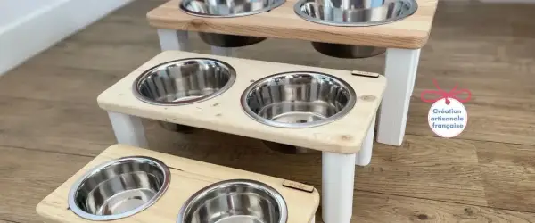 Trois gamelles pour chien en bois, sur pieds blancs, avec bols en inox. Une création artisanale française pour le repas de votre compagnon.